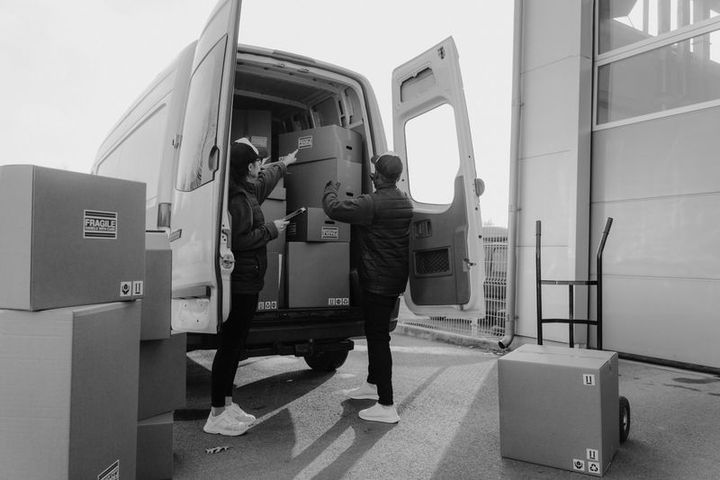 Movers loading boxes into a rental truck during a labor-only move
